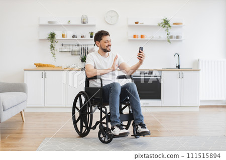 Wheelchair user holding online conference in home interior 111515894