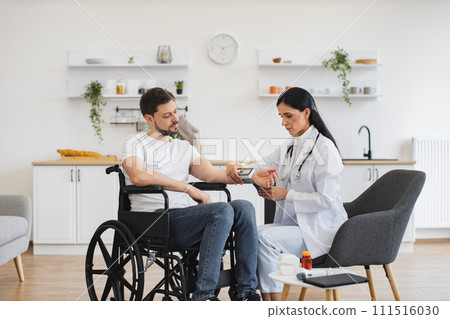 Cardiologist telling patient with disability about all reasons of hypertension. 111516030