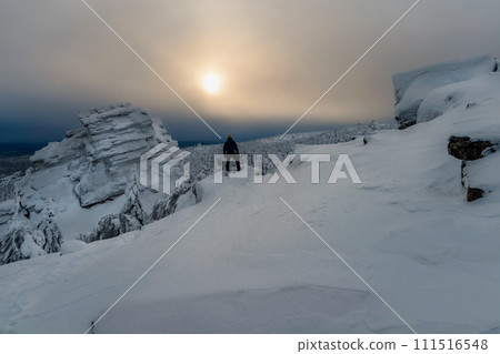 Man photographer stands over the cliff and looks into the distance. 111516548