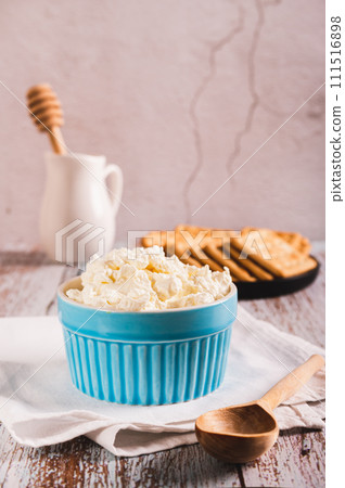 Traditional mascarpone cheese in a bowl on the table vertical view 111516898