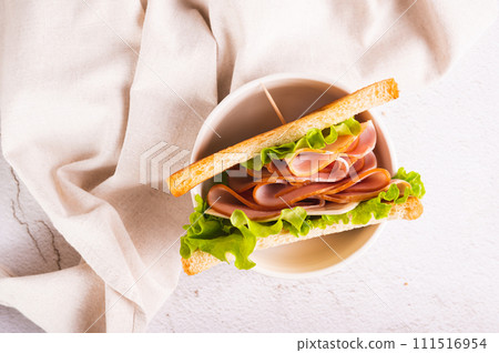 Close up of sandwich with ham, cheese and onion in a bowl on the table top view 111516954