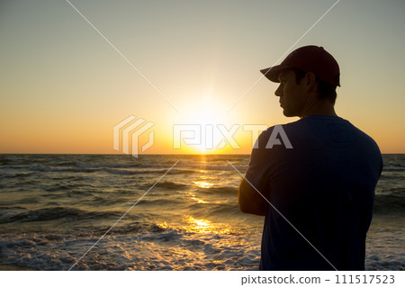 Portrait of a young man in cap on the beach 111517523
