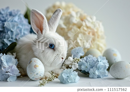 White Bunny with blue eyes surrounded by pastel colored eggs and blooming hydrangeas White Bunny with blue eyes surrounded by pastel colored eggs and blooming hydrangeas 111517562