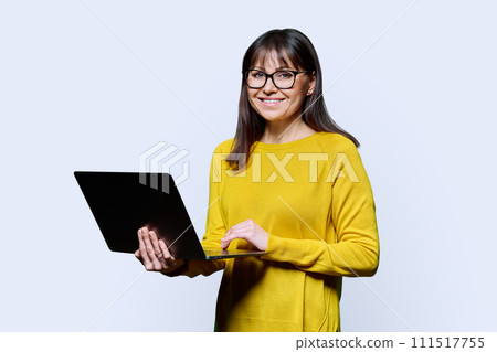 Middle-aged woman using laptop computer on white studio background Middle-aged woman using laptop computer on white studio background 111517755