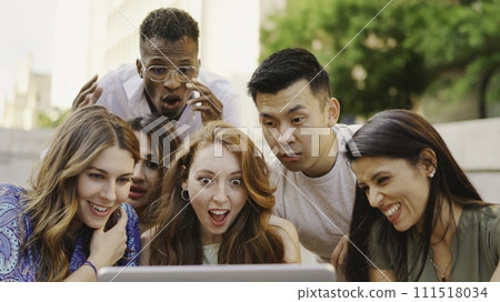 Multiethnic group of people looking at a laptop with surprised expression 111518034