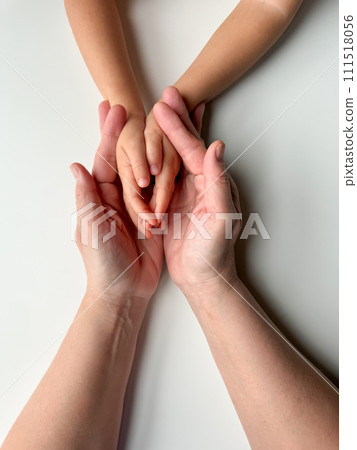 Mothers hands holding childs hands on a white background. Mothers hands holding childs hands on a white background. 111518056