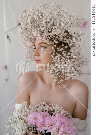 Portrait of sensual blond woman with flowers. Beautiful girl with flowers in her hair. Summer Beauty. Art in a contemporary style. A gypsophila wreath on a white background. Perfume, cosmetics concept 111518416