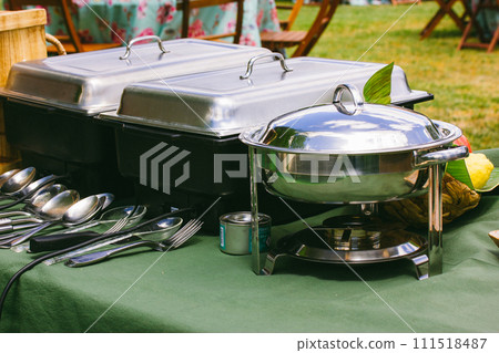 Outdoor kitchen equipment. Preparing food on a barbecue party. Food tray with kitchen utensils, bowls, pots and pans. Backyard banquet. Barbecue party 111518487