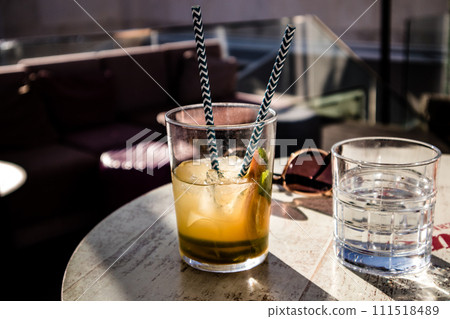 Cold drinks on wooden table in cafe. Tonic, mojito cocktail, spritz, water in drinking glass on restaurant terrace. Fresh summer drinks in sunny day. 111518489