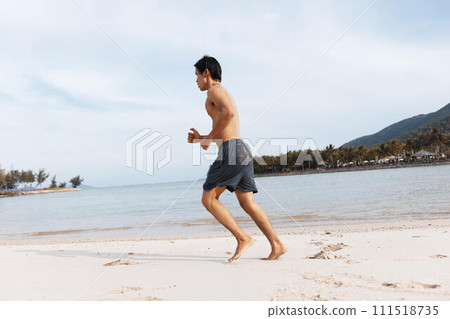 Active Asian Athlete Embracing Fitness on Sandy Beach: A Meditative Stretching Session 111518735