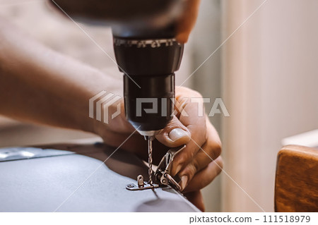 Male mechanic works with electric drill. Worker drills hole. Furniture assembler installs metal latch. Handmade, craft. Male mechanic works with electric drill. Worker drills hole. Furniture assembler installs metal latch. Handmade, craft. 111518979