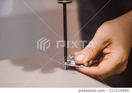 Furniture assembler installs hinges. Mechanic works with screwdriver. Hands hold repair tool. Small business support. Lifestyle work. 111518980