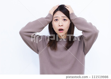 A surprised woman in her 40s holding her head A surprised woman in her 40s holding her head 111519986