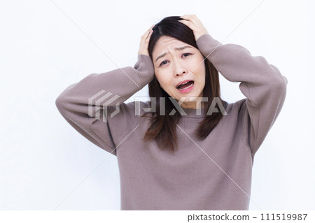 A surprised woman in her 40s holding her head 111519987