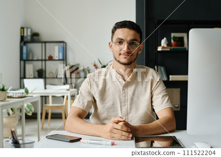 Young entrepreneur sitting by workplace 111522204