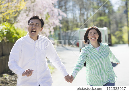 Smiling couple running holding hands Smiling couple running holding hands 111522917