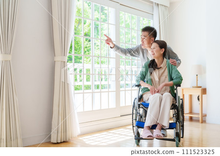 坐輪椅的中年和老年夫婦 坐輪椅的中年和老年夫婦 111523325