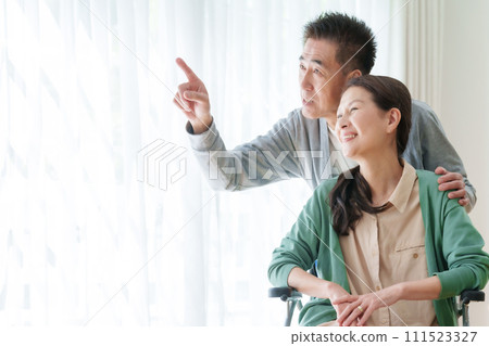 坐輪椅的中年和老年夫婦 坐輪椅的中年和老年夫婦 111523327