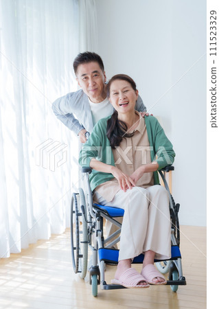 坐輪椅的中年和老年夫婦 坐輪椅的中年和老年夫婦 111523329
