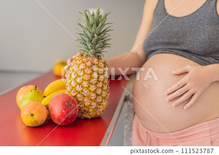 Embracing a healthy choice, a pregnant woman prepares to enjoy a nutritious moment, gearing up to eat fresh fruit and nourish herself during her pregnancy 111523787