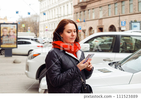 rental service concept. young Caucasian female woman calls taxi in smartphone app. woman looking for carshare car in smartphone app. transportation. female uses smart phone for checking latest news, rental service concept. young Caucasian female woman calls taxi in smartphone app. woman looking for carshare car in smartphone app. transportation. female uses smart phone for checking latest news, 111523889