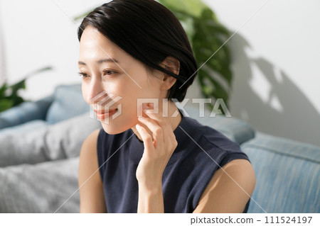 Sleeveless woman sitting on the sofa 111524197
