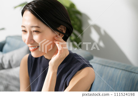 Sleeveless woman sitting on the sofa 111524198