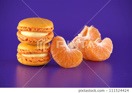 Stack of orange macaroons next to a peeled tangerine Stack of orange macaroons next to a peeled tangerine 111524424