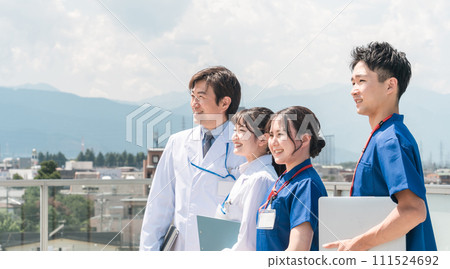Male and female doctors, doctors, nurses, medical workers, and technicians (4 people) spending their break time on the roof of a hospital Male and female doctors, doctors, nurses, medical workers, and technicians (4 people) spending their break time on the roof of a hospital 111524692