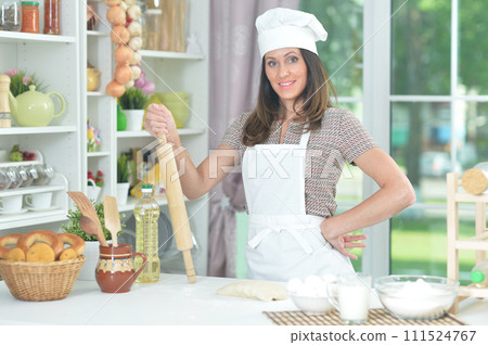 Beautiful young chief woman baking in kitchen Beautiful young chief woman baking in kitchen 111524767
