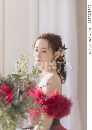 一個穿著紅色洋裝的年輕女子低下頭 111525201