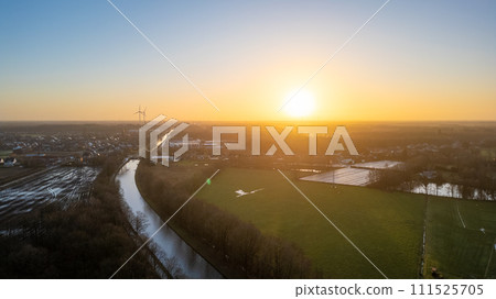 Dawn Breaks Over Wind Turbine and Canal in Countryside Dawn Breaks Over Wind Turbine and Canal in Countryside 111525705