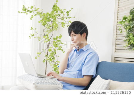 A man using a laptop while thinking in the living room 111526130