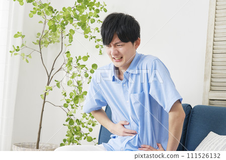 A man with stomachache in the living room A man with stomachache in the living room 111526132