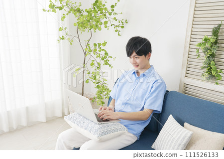 A man using a laptop in the living room 111526133