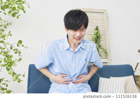A man with stomachache in the living room A man with stomachache in the living room 111526138