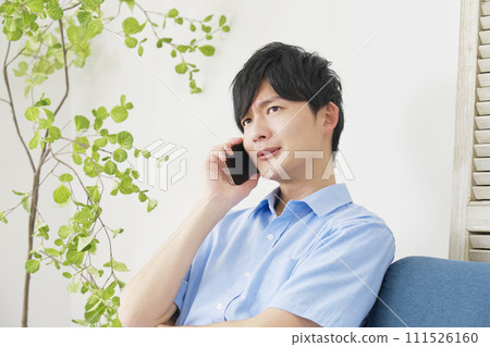 A man calling on a smartphone in the living room 111526160