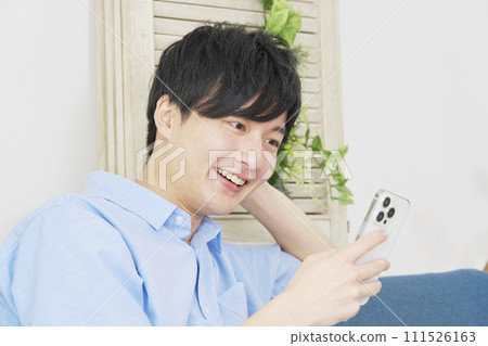 一個在客廳裡使用智能手機的人 111526163