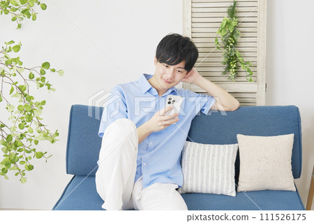 A man who uses smartphones in the living room 111526175