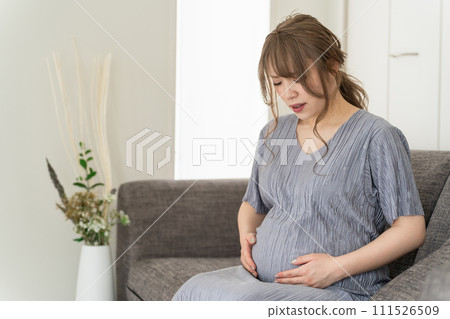 孕婦/產婦坐在家裡沙發上(腹痛、破水、懷孕後期) 孕婦/產婦坐在家裡沙發上(腹痛、破水、懷孕後期) 111526509