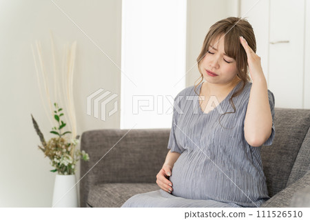 孕婦/產婦坐在家裡沙發上(頭痛、感冒、懷孕後期) 孕婦/產婦坐在家裡沙發上(頭痛、感冒、懷孕後期) 111526510