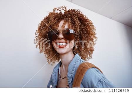 Joyful Lady with Afro Hairstyle, Laughing and Smiling in Bright Yellow Sunglasses on a Stylish White Background 111526859