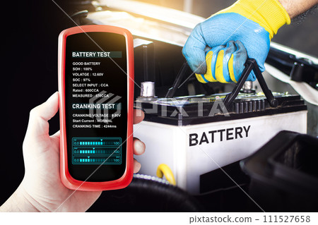 Battery tester in a car mechanic hand for testing battery voltage and battery health Battery tester in a car mechanic hand for testing battery voltage and battery health 111527658