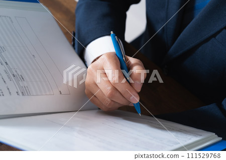 Hand of a businessman checking a file Hand of a businessman checking a file 111529768
