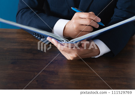 Hand of a businessman checking a file Hand of a businessman checking a file 111529769