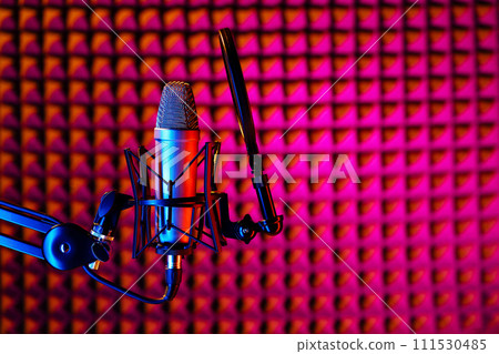 Professional studio microphone against acoustic foam panel background in neon light 111530485