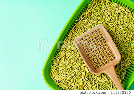 Pet litter box with bio filler on green background Pet litter box with bio filler on green background 111530530