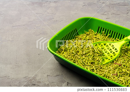 Pet litter tray with wooden filler on gray background Pet litter tray with wooden filler on gray background 111530883