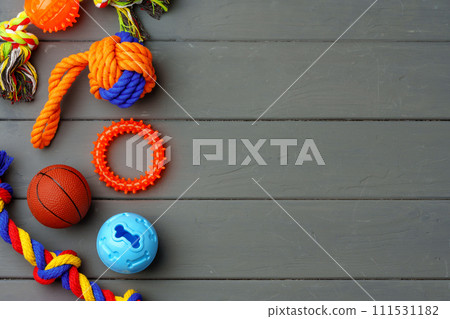 Pet toys on gray wooden background close up 111531182