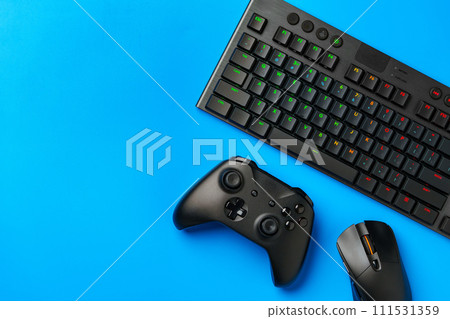 Computer keyboard and joystick on blue background top view 111531359